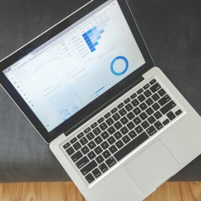 Overhead view of a laptop showing data visualizations and charts on its screen.