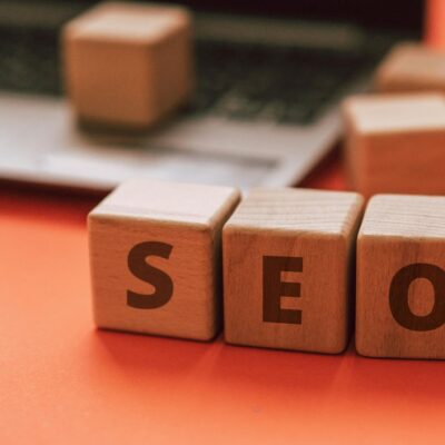 Wooden blocks spelling SEO on a laptop keyboard convey digital marketing concepts.